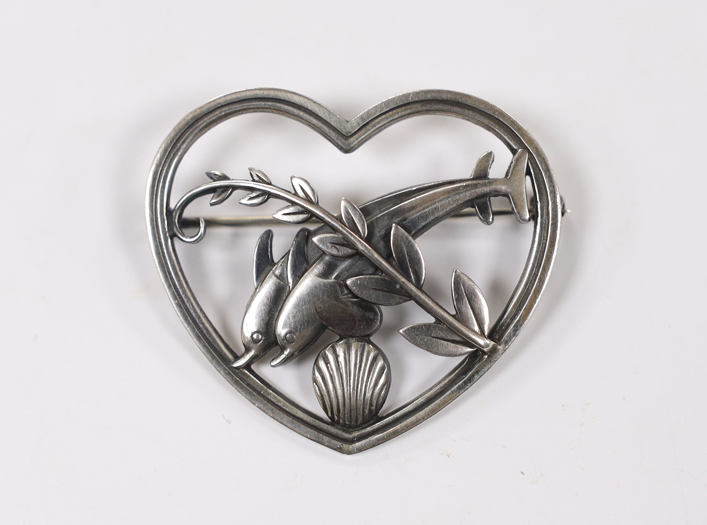 A George Jensen sterling 'twin dolphin, shell and frond' heart shaped brooch, design no. 312, width 41mm.